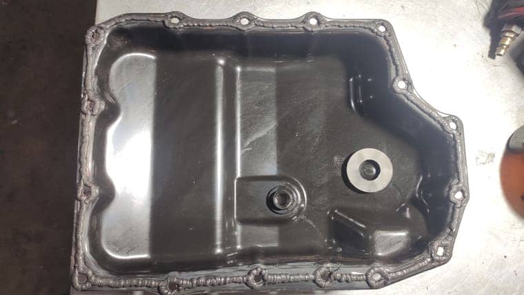 Очищаем поддон АКПП от старого герметика, масла. Очищаем магнит от продуктов износа. Наносим новый герметик.