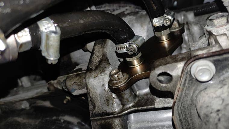 Устанавливаем специальный переходник вместо штатного теплообменника и подключаем к нему патрубки установки для замены масла.