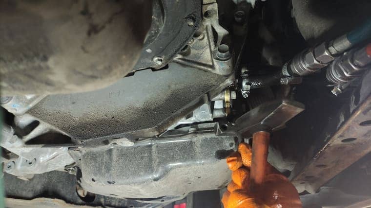 Откручиваем болты крепления поддона АКПП. Поддон приклеен на герметике. Для его демонтажа используем специальный инструмент.