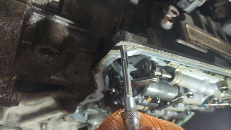 Прогоняем метчиком резьбу болтов поддона в картере АКПП, очищаем её от грязи, ржавчины и окислов.