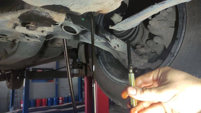 Откручиваем сливную пробку и переливную трубку в поддоне АКПП. Сливаем масло с картера АКПП.