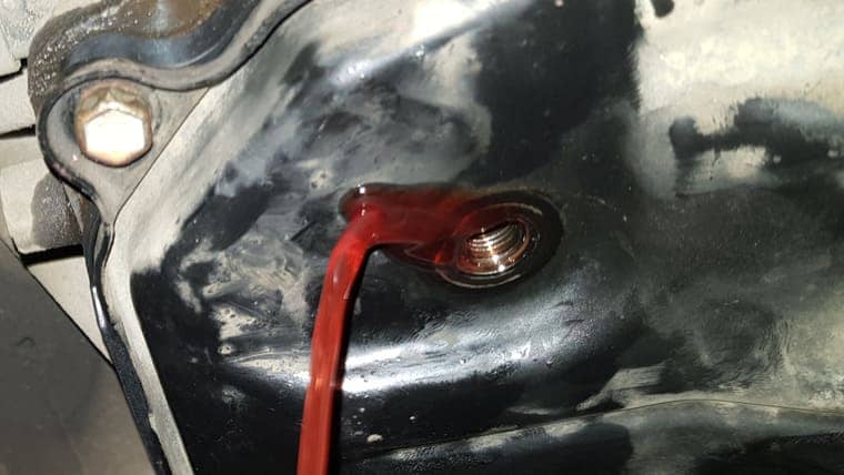 Запускаем двигатель автомобиля. Переключаем селектор АКПП по всем передачам, задерживаясь на каждой на 2–3 секунды. Переводим селектор в положение “Р”. Выкручиваем сливную пробку. Масло вытекает до отдельных капель. Закрываем контрольную пробку. Работа по замене масла в АКПП завершена.