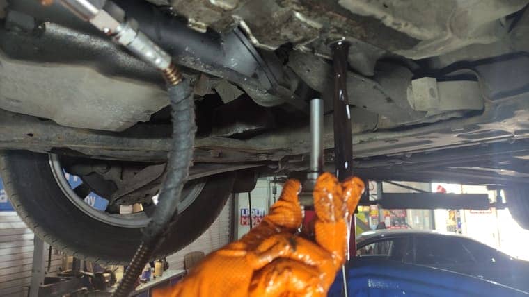 Откручиваем сливную пробку и сливаем старую трансмиссионную жидкость из картера АКПП.