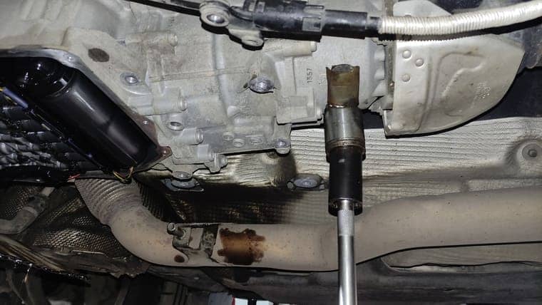 Устанавливаем трансмиссионную стойку под заднюю часть трансмиссии и снимаем поддон.