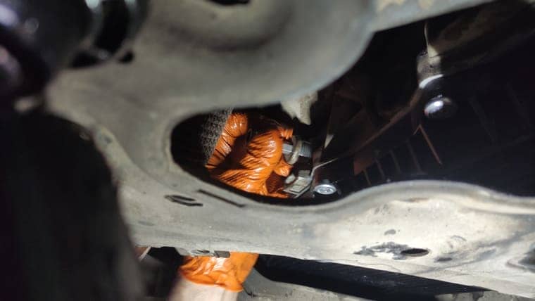 Запускаем автомобиль, переключаем передачи по всем диапазонам. Ставим селектор в паркинг и откручиваем контрольную пробку.