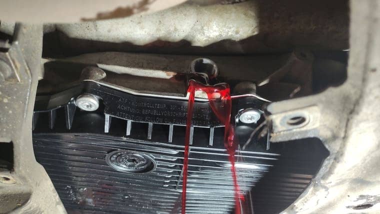 Масло вытекает из контрольного отверстия до отдельных капель.