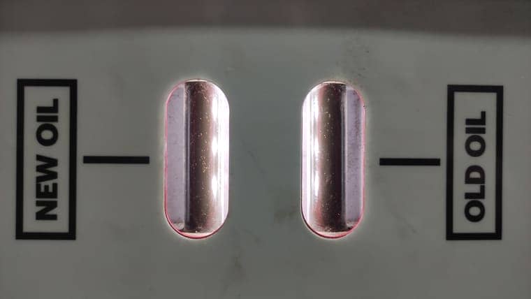 После запуска двигателя автомобиля трансмиссионное масло циркулирует через установку. В смотровых окнах видно его состояние. Старое масло довольно темное и его ресурс подходит к концу.