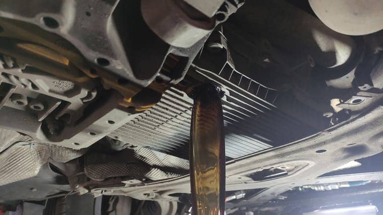 Откручиваем сливную пробку на поддоне и сливаем часть старого масла. Сливается около 5‑ти литров. Половина масла остается в скрытых полостях коробки. Его можно удалить только при снятии и разборе АКПП, или при помощи установки для замены масла.