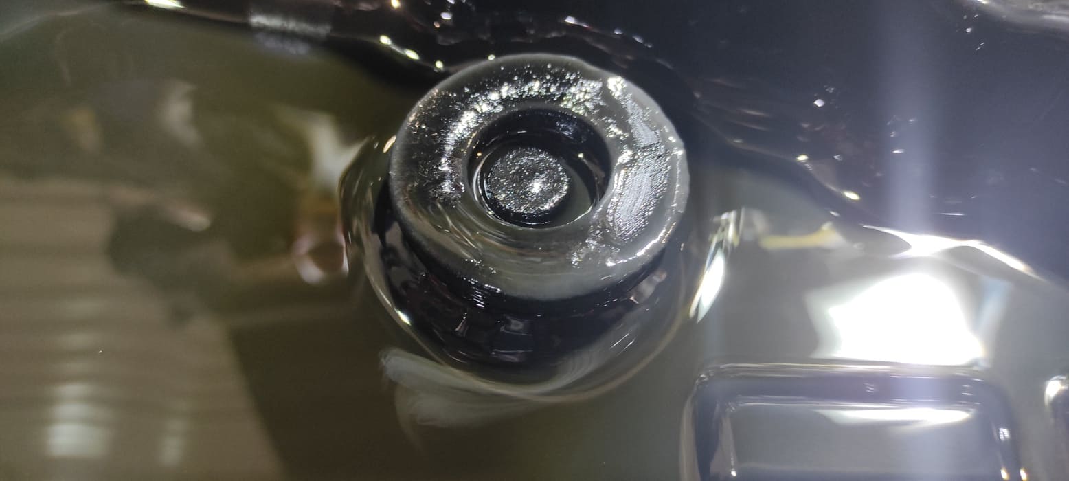 Загрязнения на магните крупным планом. Часть участка смазана для просмотра в толще слоя загрязнений.