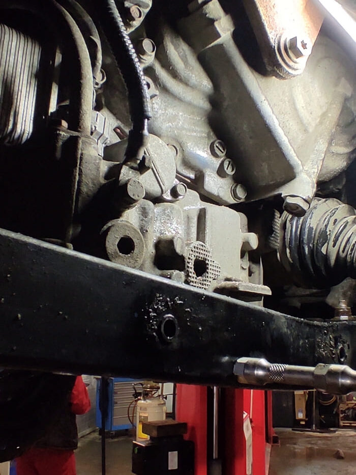 На фото крышка стакана фильтра тонкой очистки масла видна в центре, позади штуцера, к которому прикреплён черный шланг. Стакан крепится одним болтом и дополнительно фиксируется замковым соединением.