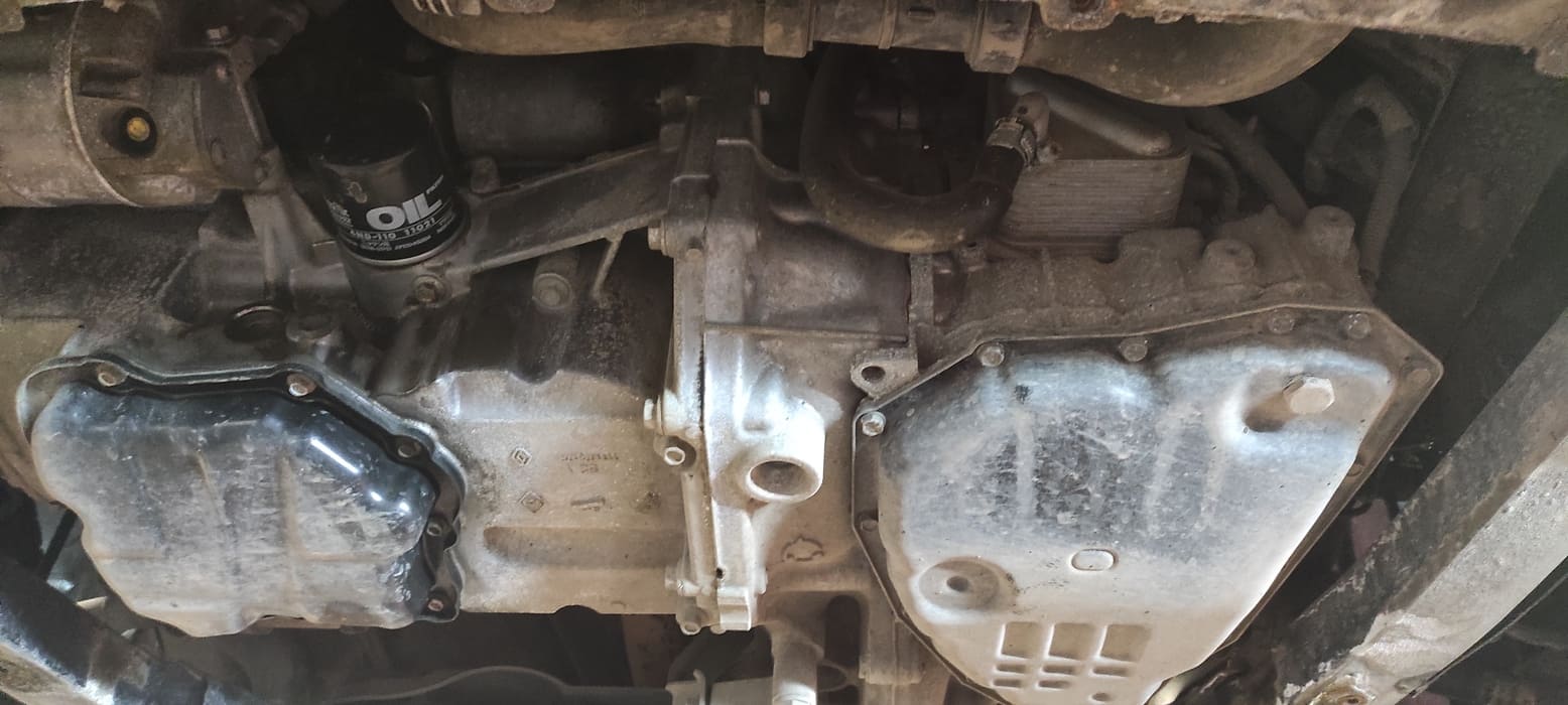 Слева поддон двигателя, справа поддон вариатора. Выше поддона виден теплообменник для охлаждения масла вариатора. Сняв теплообменник, через специальный переходник мы подключим к вариатору установку для аппаратной замены масла.